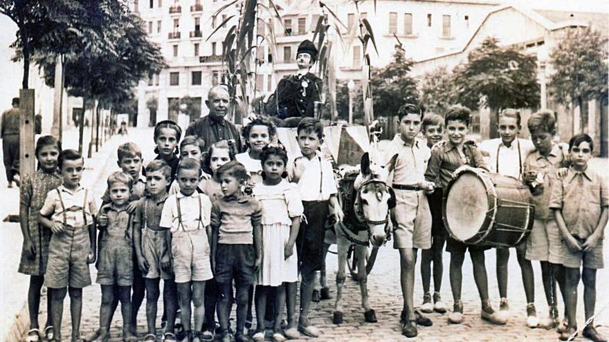 Uns nens acompanyant el Tarlà; a Joan Ribas se’l veu a baix de la figura.