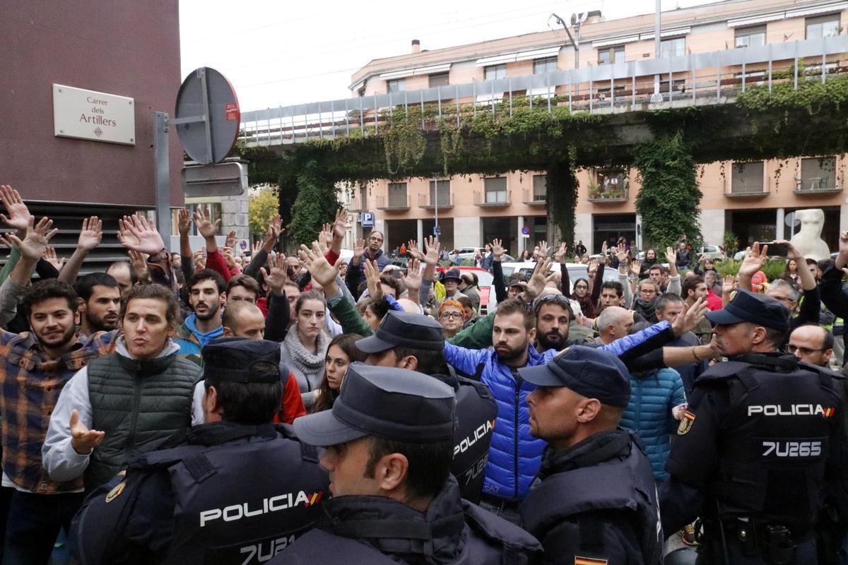 Diversos votants amb les mans alçades davant la policia el diumenge 1 d'octubre de 2017.