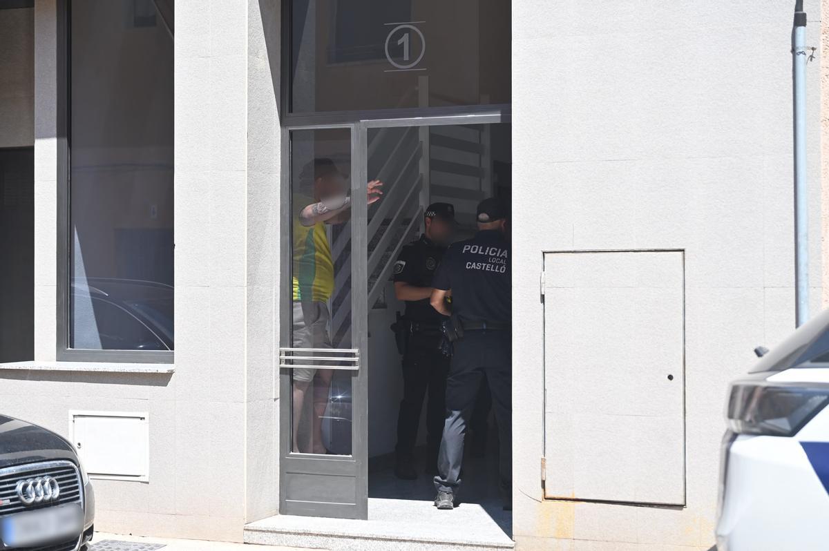 Los agentes junto al okupa en el interior del portal.