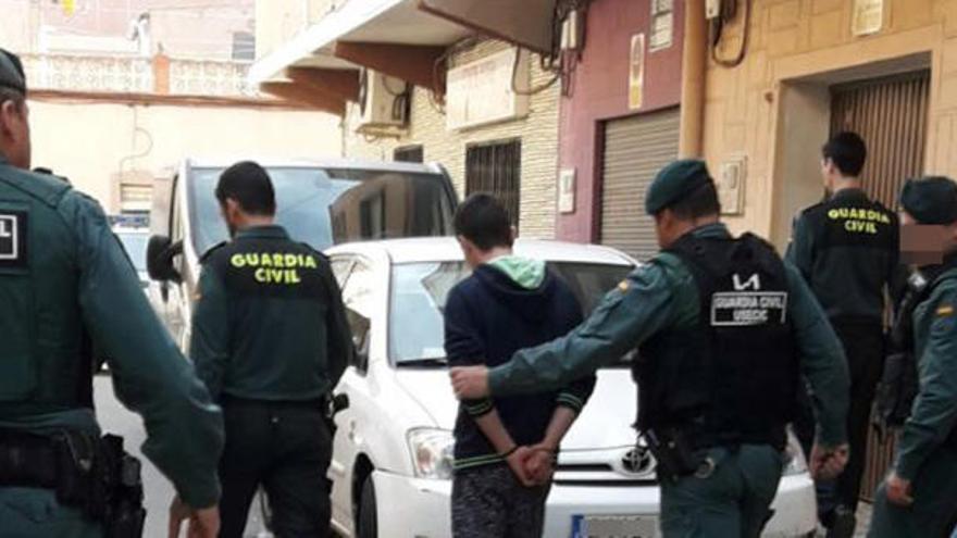 Los agentes custodian a uno de los detenidos.