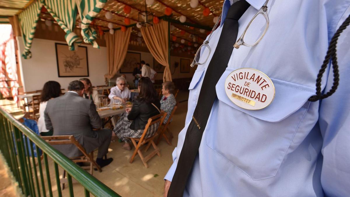 Un vigilante de seguridad fetén, con su placa y todos sus avíos, haciendo su trabajo durante esta pasada semana de farolillos. / Fotos: Jesús Barrera