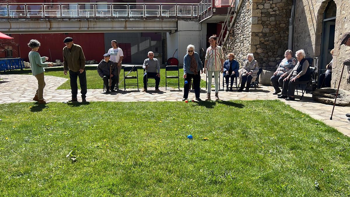 Un grup d'usuaris de l'Espai Obert de la Fundació Adis jugant a petanca al jardí del Museu Cerdà