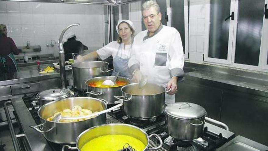 Arriba, Yolanda Suárez y Fernando Iglesias, entre fogones. A la derecha, un momento de la elaboración.