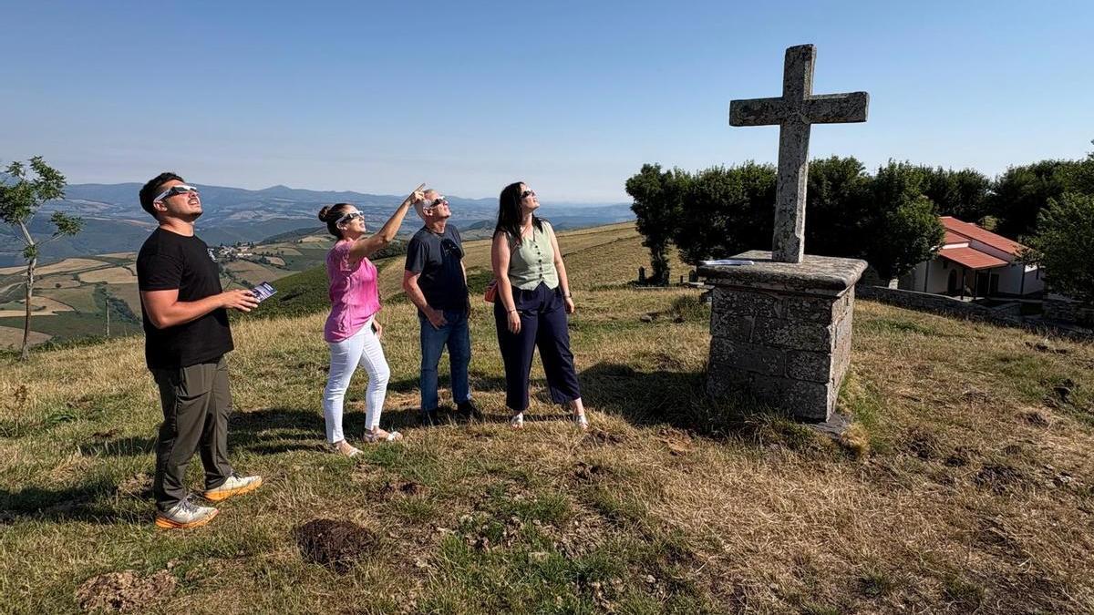 Por la izquierda, Alberto Fernández, Ana Llano y los concejales José Manuel Menéndez y Tania Rodríguez miran al sol con las gafas del eclipse que repartirá la asociación de turismo rural, el alto del Acebo.