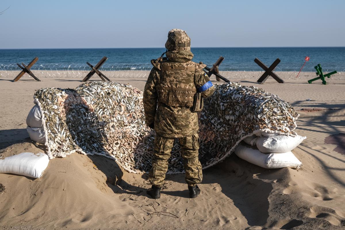 Un soldado ucraniano hace guardia con su arma junto a las barricadas en la playa cerca de Lusanivka en la ciudad de Odesa, en el sur de Ucrania.