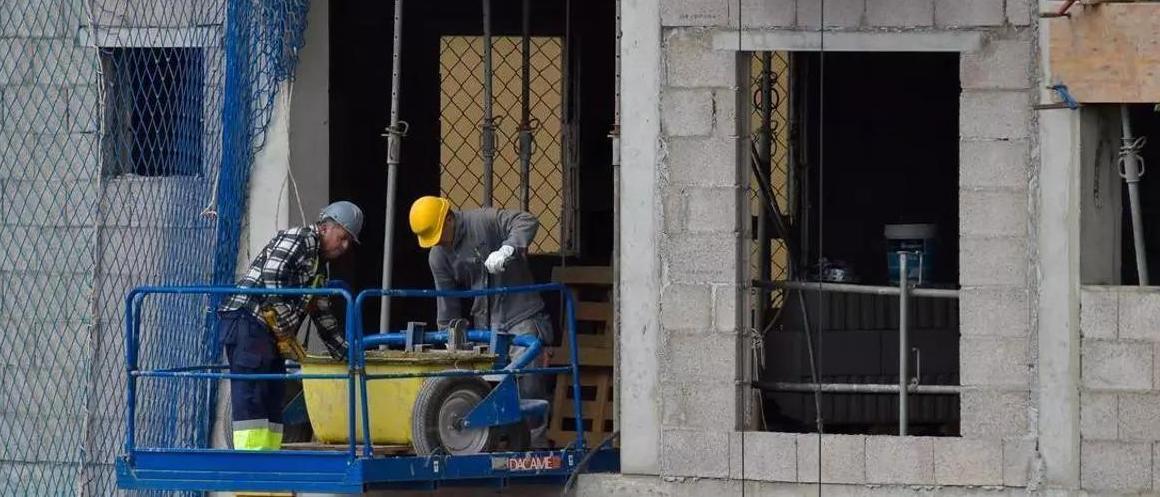 Dos obreros trabajando en una obra.