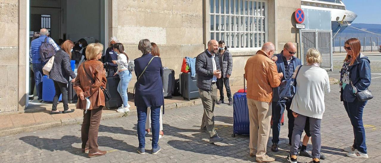 La decena de cruceristas de Vigo, listos para embarcar en el Queen Elizabeth, al fondo