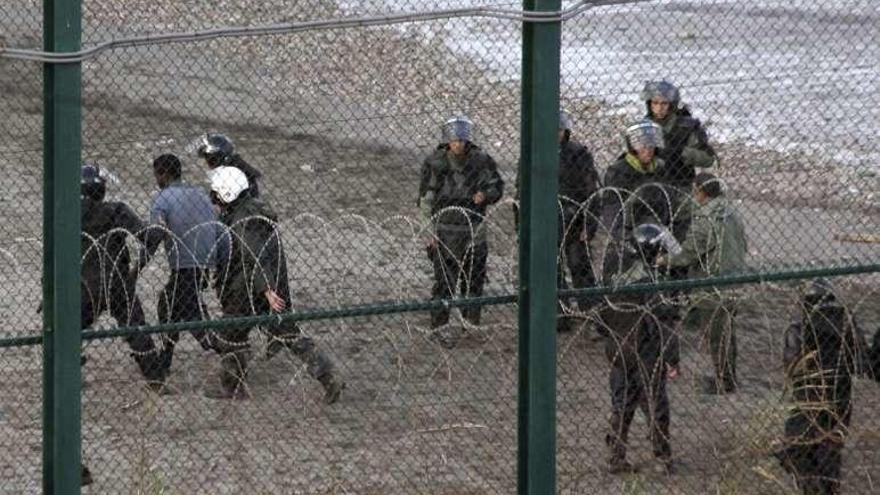 Gendarmes detienen a inmigrantes, ayer, en la frontera con Ceuta. // Efe