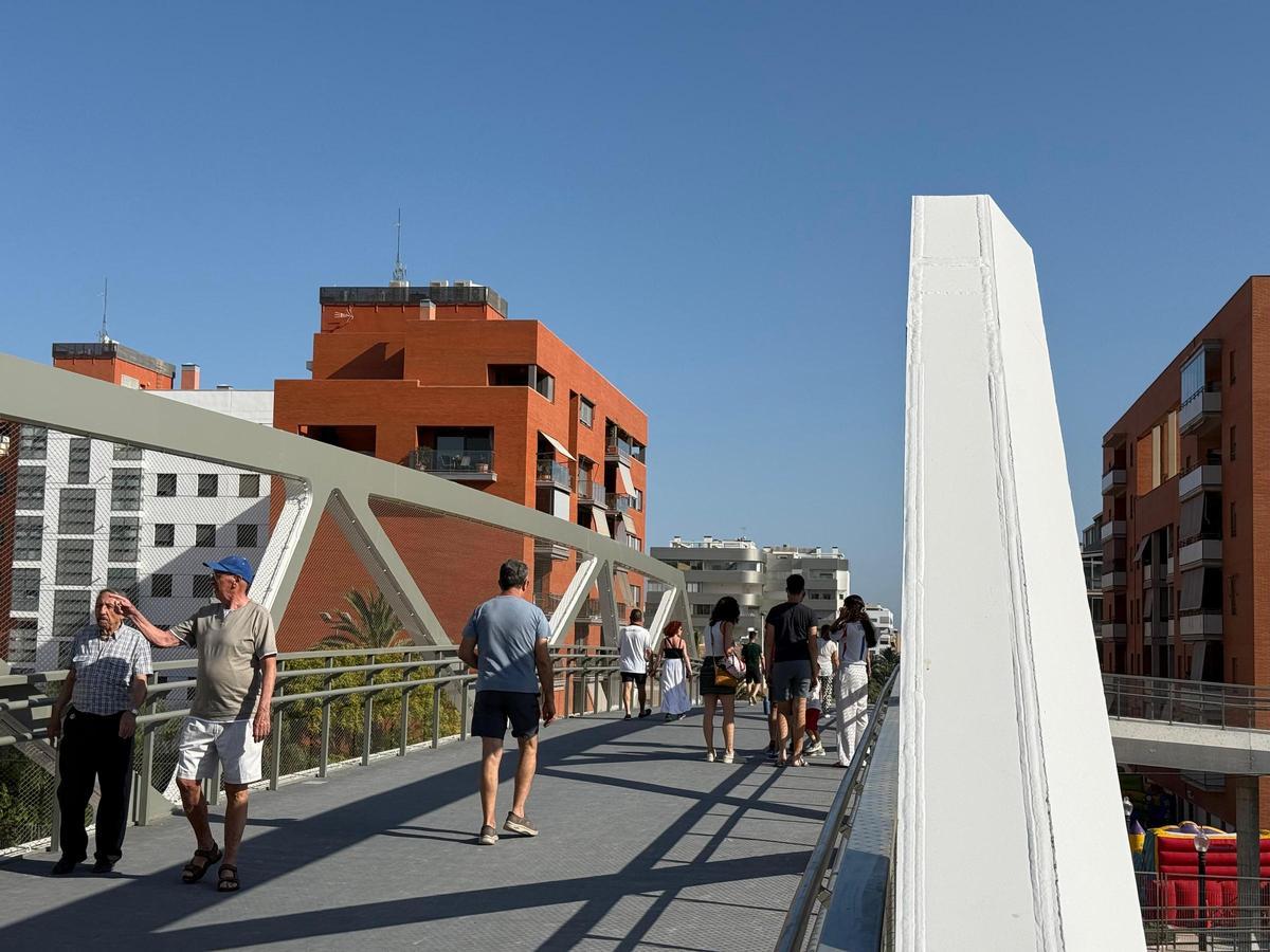 Vecinos transitando por la nueva pasarela elevada sobre las vías del tren en Altabix