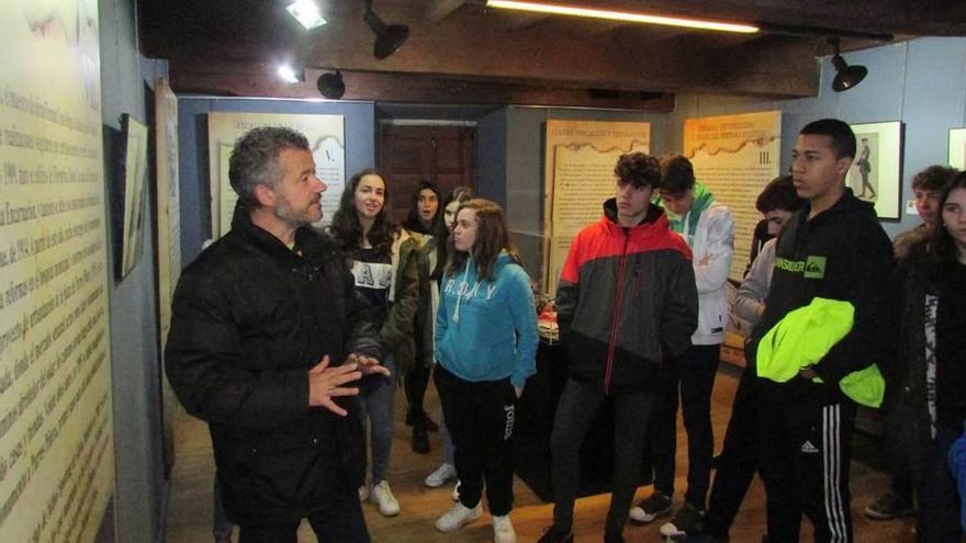 El profesor Eduardo Carrero y los estudiantes, durante la visita a la exposición, ayer, en Llanes.