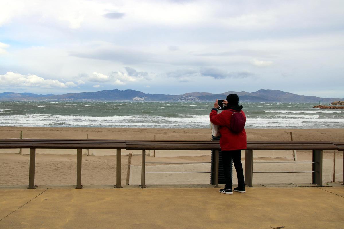 Un home fa una foto al mar de l'Escala