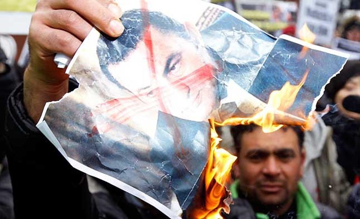 Egipcis que viuen a Corea del Sud aguanten un retrat en flames del president Hosni Mubàrak, a prop de l’ambaixada d’Egipte a Seül.