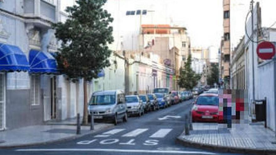 Una niña y su madre caminan a través de la calle Molino de Viento, en el barrio de Arenales. A la izquierda, un local de prostitución.