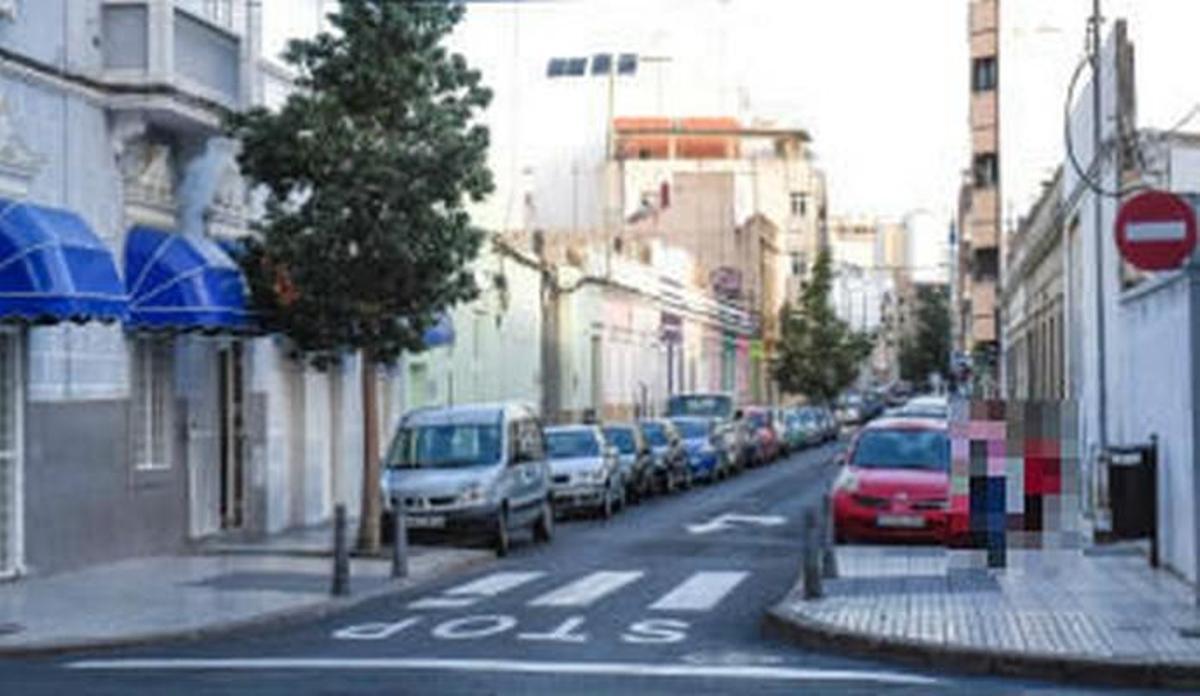 Una niña y su madre caminan a través de la calle Molino de Viento, en el barrio de Arenales. A la izquierda, un local de prostitución.
