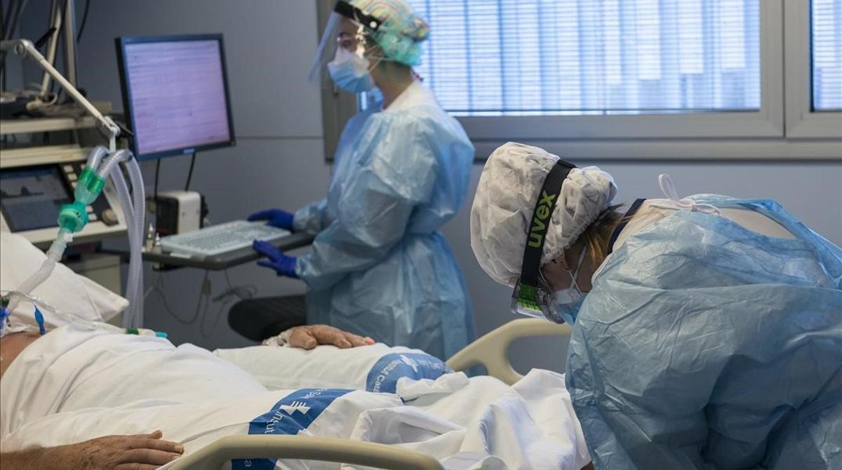 Personal sanitario atendiendo a un paciente ingresado en la Unidad de Cuidados Intensivos (UCI) para enfermos de coronavirus del Hospital Universitario Dr  Josep Trueta de Girona  Catalunya (Espana)  a 21 de diciembre de 2020  Cataluna ha amanecido hoy con nuevas restricciones  entre ellas  la movilidad a la comarca durante toda la semana  para afrontar el repunte del Covid-19 en Catalunya y ante  la posible llegada de una tercera ola que incremente el nivel de presion sobre los recursos sanitarios   A dia de hoy hay 1 623 pacientes ingresados en hospitales catalanes con covid-19 y 327 personas en las UCIS   21 DICIEMBRE 2020 HOSPITAL UNIVERSITARIO DR JOSEP TRUETA GIRONA UCI INGRESOS PACIENTES HOSPITAL CORONAVIRUS COVID 19 ENFERMOS REPUNTE CASOS  Gloria Sanchez   Europa Press  21 12 2020
