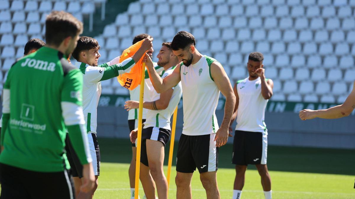 Kevin Medina y Xavi Sintes bromean en el inicio del último entrenamiento semanal del Córdoba CF, previo al partido frente al Albacete Balompié.