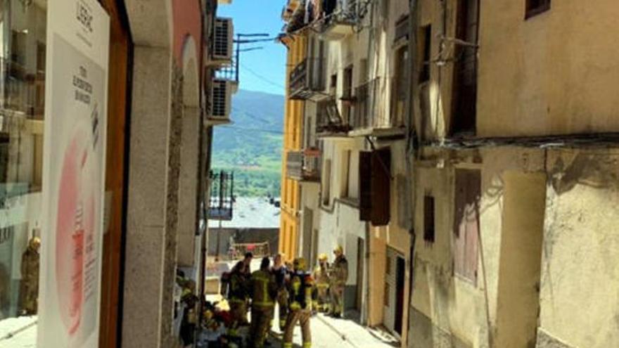 Edifici afectat pel foc a Puigcerdà i bombers treballant al carrer