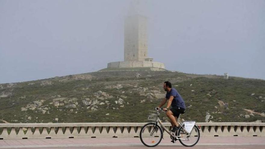 Un ciclista pedalea frente a la Torre en el paseo marítimo. / eduardo vicente