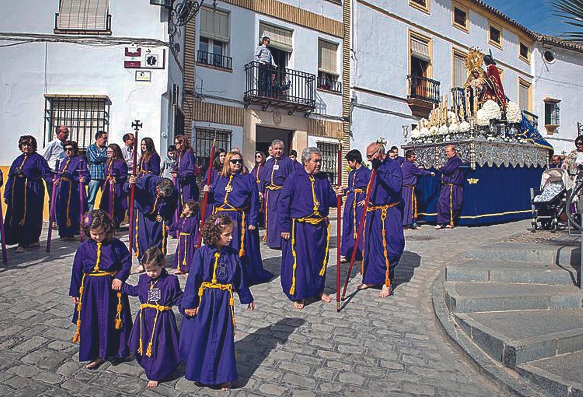 Penitentes con cordón amarillo y los pies descalzos el Viernes Santo.