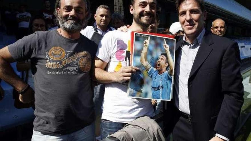 El nuevo entrenador del Celta se fotografía con dos aficionados.