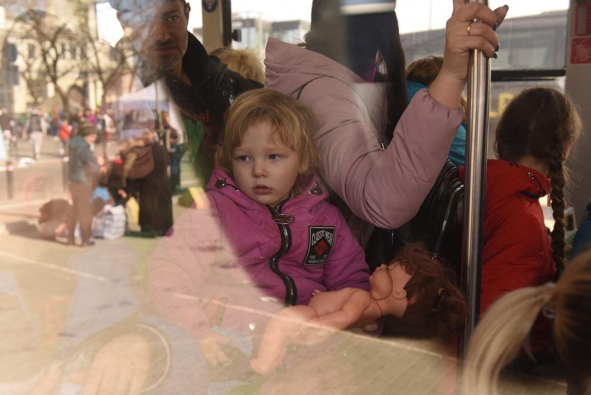 Evacuados del este de Ucrania se sientan en un autobús en ruta a la frontera polaca desde la ciudad de Lviv, en el oeste de Ucrania.