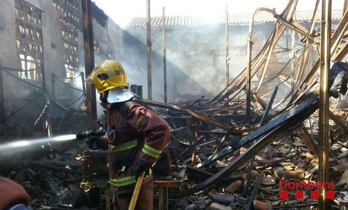 Bomber treballant en l'extinció del foc que va destruir una nau de la Colònia Sedó.