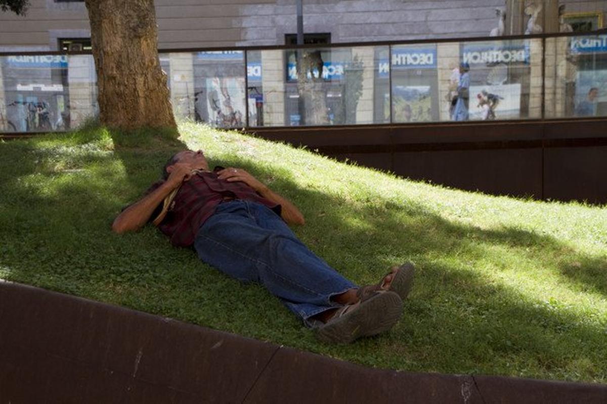Un jove fa la migdiada en una plaça de Barcelona, en una imatge d’arxiu. Un jove fa la migdiada en una plaça de Barcelona, en una imatge d’arxiu.