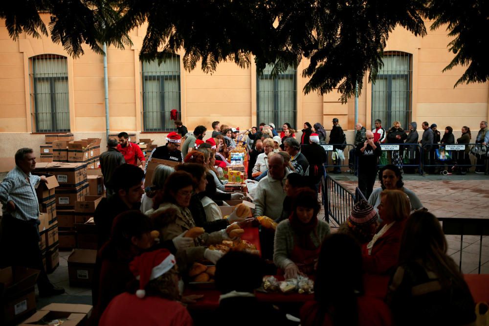 People receive food during a daily food ...