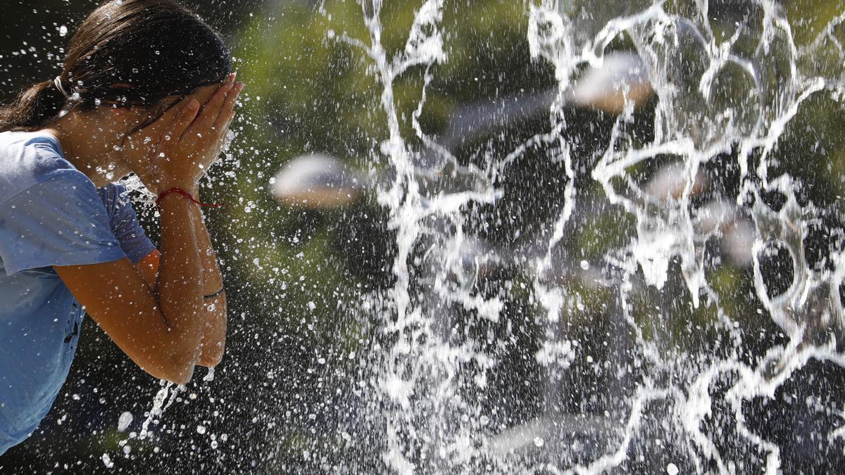 Una mujer se refresca en una de las fuentes de Córdoba