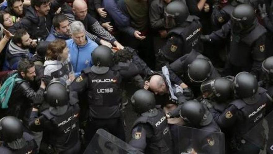 Membres del cos de policia intentant entrar a un punt de votació.