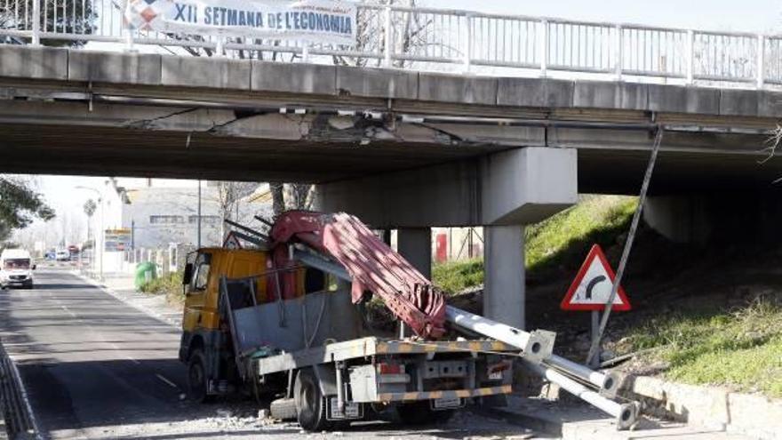 La grúa, con el chasis doblado, bajo el puente José Pellicer (CV-50) tras el impacto.