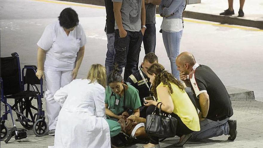 Los servicios médicos atienden a una mujer en el exterior del hospital de A Coruña. // Carlos Pardellas