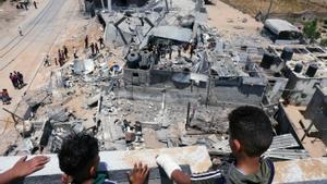 Unos civiles palestinos inspeccionan los restos de sus casas después de un ataque israelí.