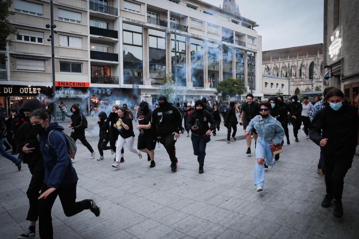 Los disturbios se extienden por Francia en la cuarta noche de protestas. Los manifestantes huyen de botes de gas lacrimógeno lanzados durante una manifestación en Caen, noroeste de Francia