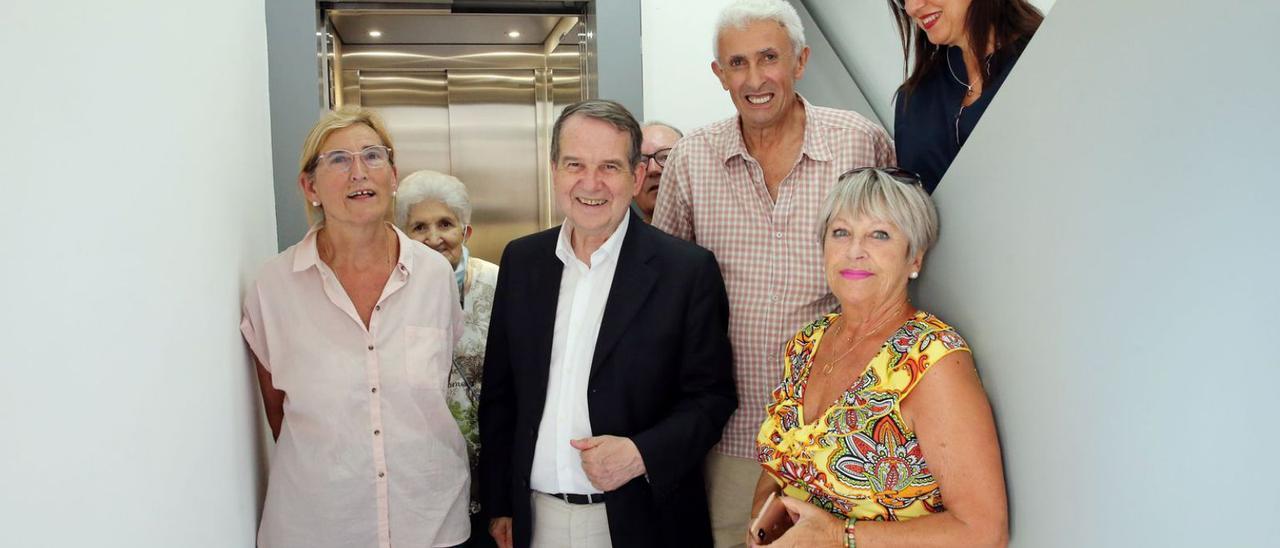 Caballero y Caride, a su izquierda, posan con vecinos  del edificio de Vilagarcía 6 delante del nuevo ascensor.   | // M.G. BREA