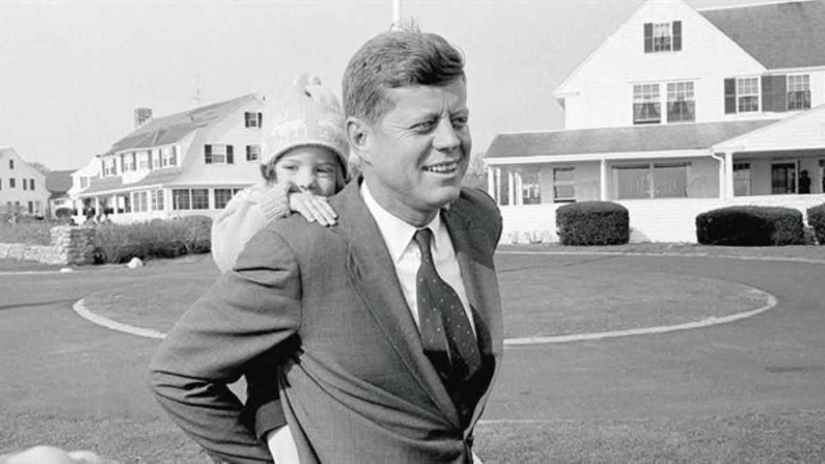 Kennedy carga a caballito a su hija Caroline durante la campaña para las elecciones presidenciales, en noviembre de 1960, en Hyannis Port, Massachusetts.