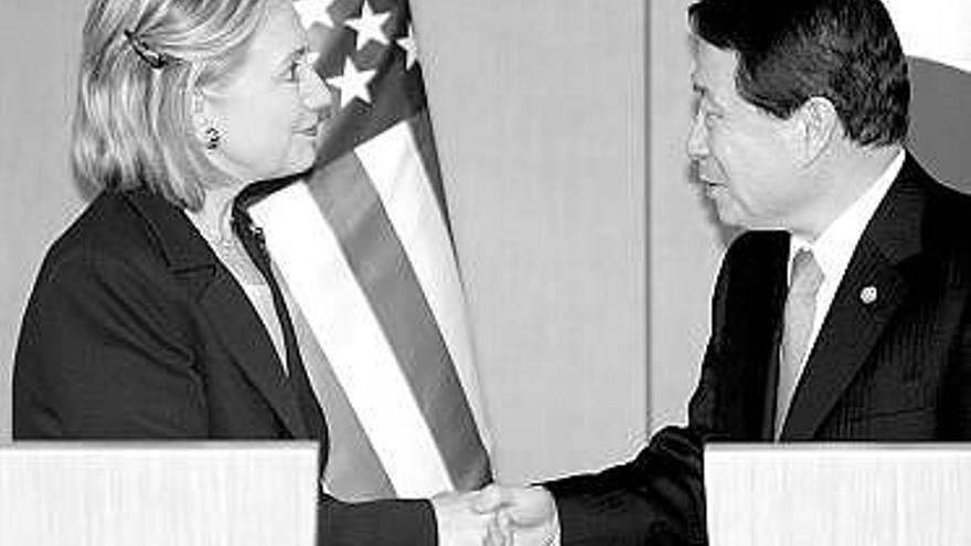 Clinton estrecha la mano de su homólogo surcoreano, Yu Myung-hwan.