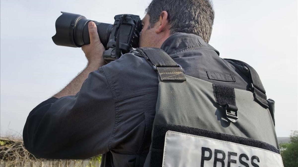 FOTO BAJADA DE 123RF EL 20 DE ABRIL DEL 2021  A press photographer takes photos with a professional camera  UN FOTOGRAFO DE PRENSA TOMA FOTOS CON UN CHALECO DONDE PUEDE LEERSE  PRENSA   PRESS  PRENSA  PERIODISMO  REPORTERO  REPORTERISMO  FOTOGRAFIA  FOTOGRAFO  FOTO DE 123RF Rafael Ben-Ari Chameleons Eye