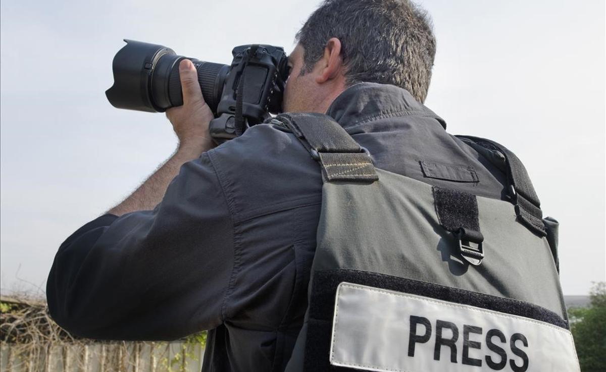 Un fotógrafo de prensa trabajando. Un fotógrafo de prensa trabajando.