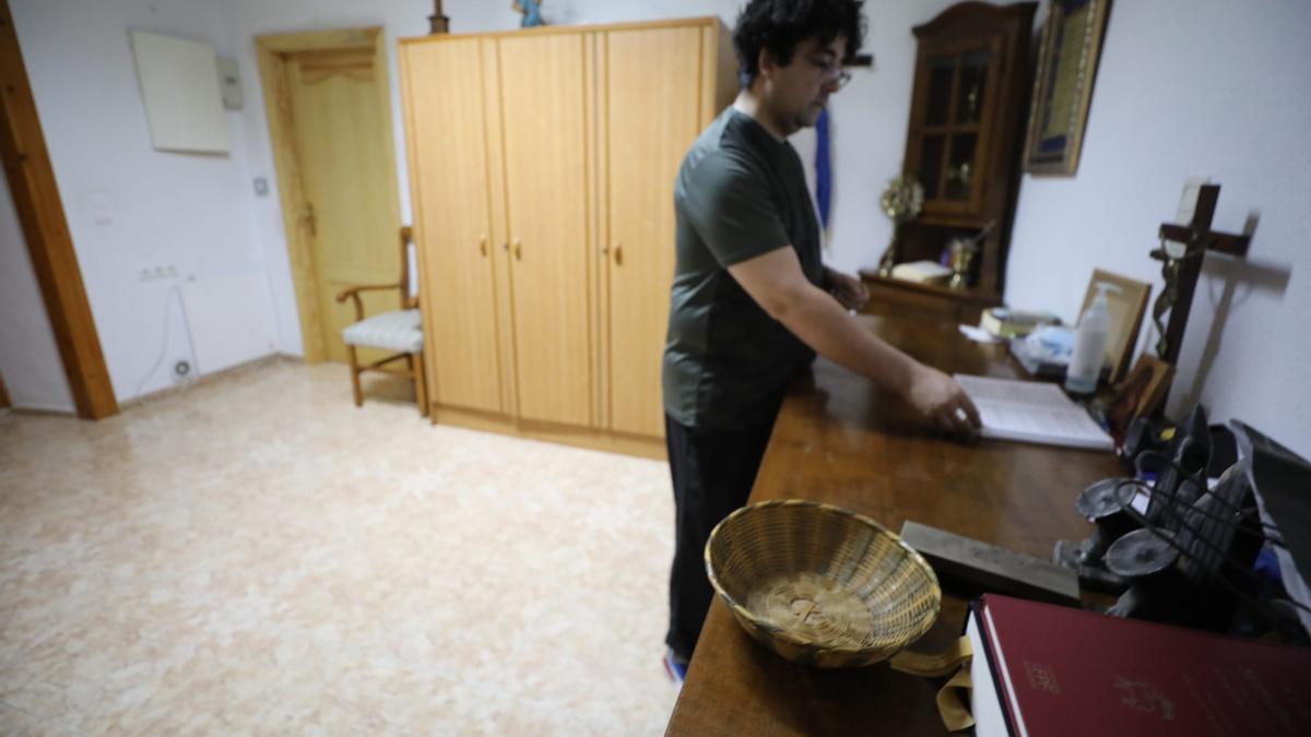 El párroco de la iglesia San Francisco de Asís de El Altet junto a uno de los cepillos y en la zona donde se produjo el robo