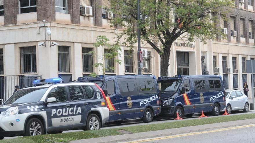 Furgones de la Policía Nacional, ayer en la puerta del Palacio de Justicia de Murcia.