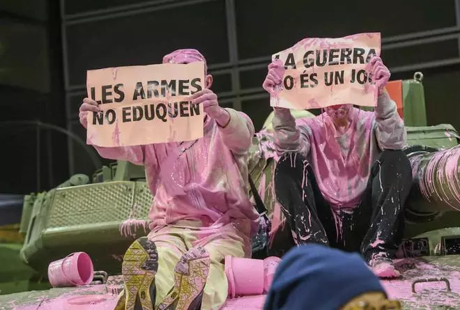 Unos pacifistas rocían pintura rosa sobre una tanqueta en Expojove: "Las armas no educan"
