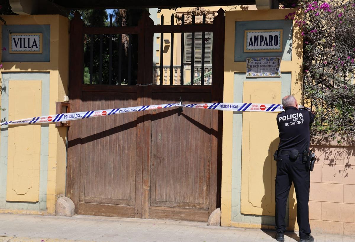 Un agente precinta la puerta de Villa Amparo tras la salida de los okupas