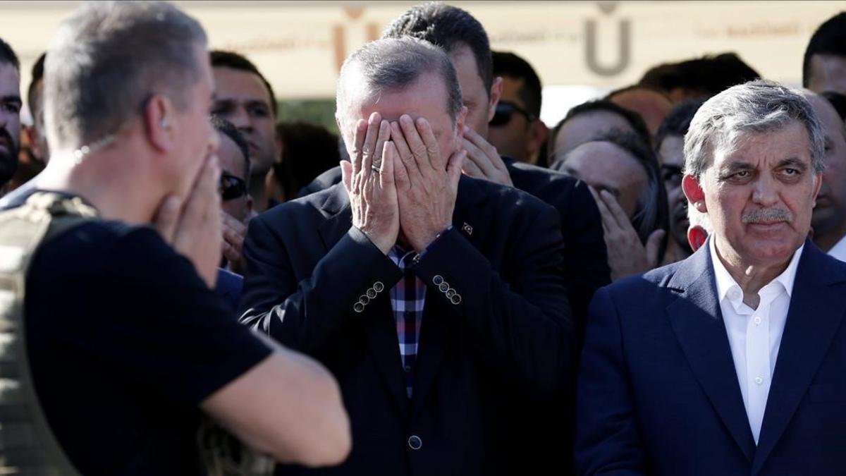 Erdogan reza junto al expresidente turco Abdulá Gul (derecha) en el funeral por los muertos en el golpe de Estado fallido.