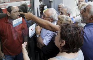 Pensionistes discuteixen amb un empleat d’una oficina tancada del Banc Nacional de Grècia.