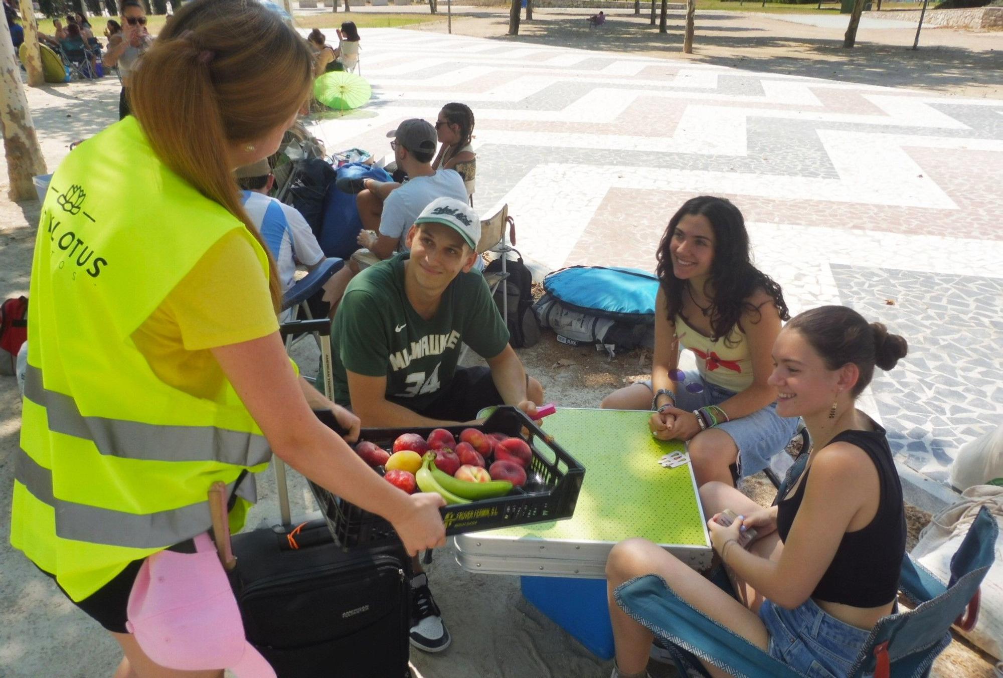 Una trabajadora del festival reparte fruta a la espera de abrir la zona de acampada, este mediodía.