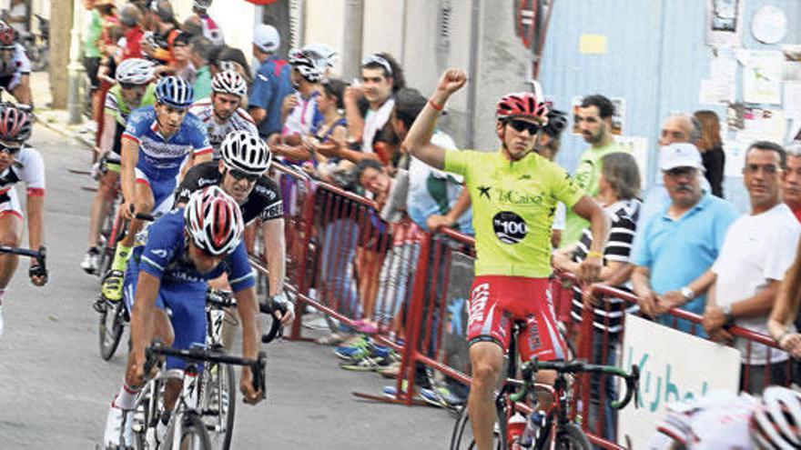 Rubén Sánchez entra en meta, en el seno del gran pelotón, celebrando su victoria en la general.