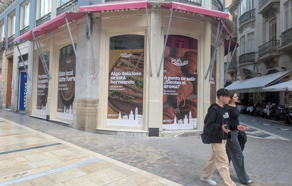 El antiguo local de la pastelería Lepanto, en la calle Larios, ya luce los carteles anunciado la apertura de La Canasta.