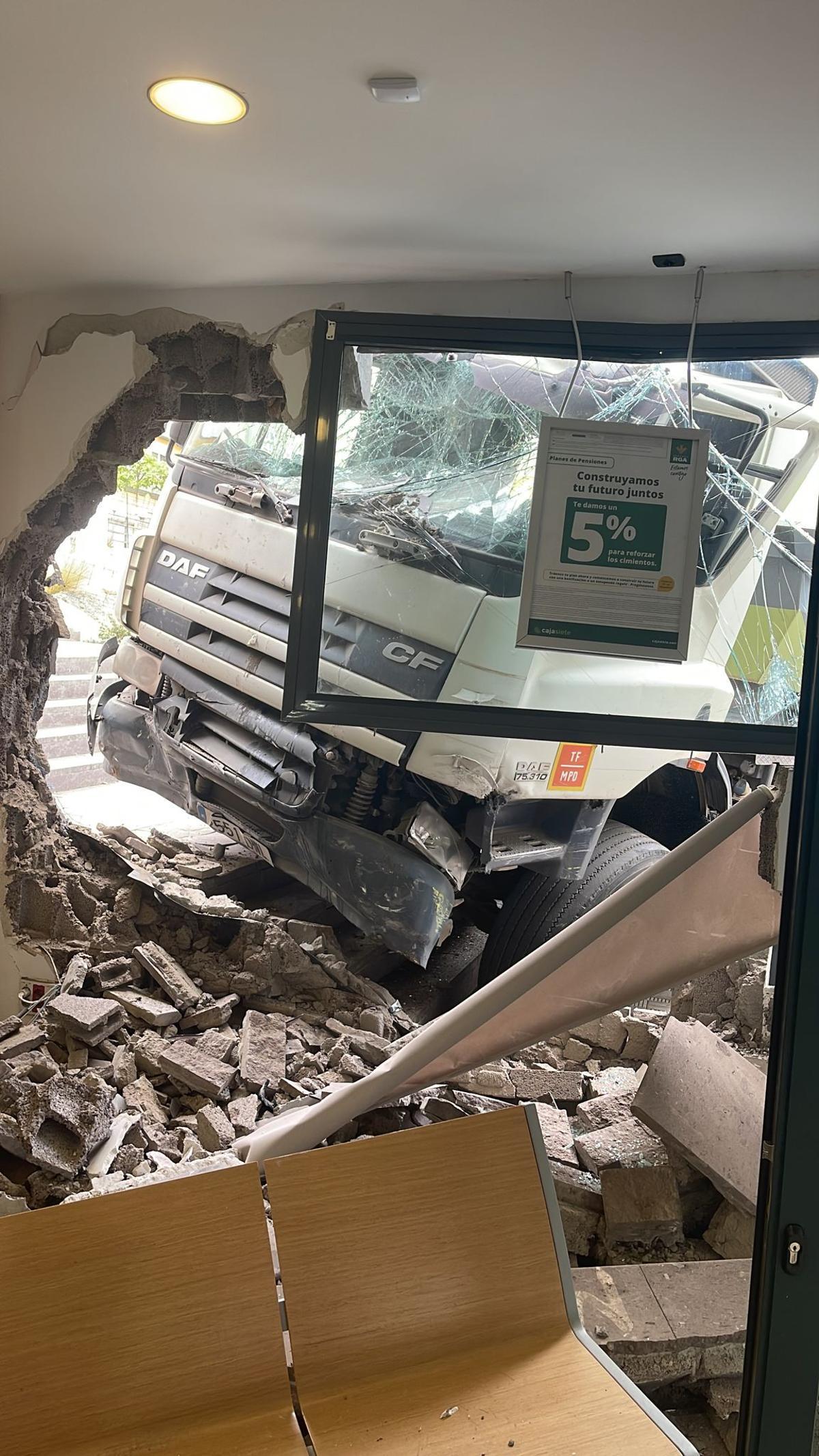 Camión empotrado con la pared del banco desde el interior de la sucursal.