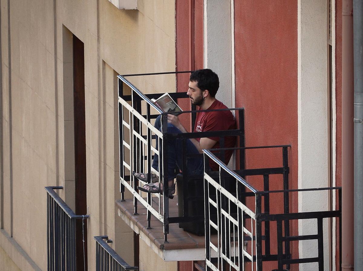 Un joven leyendo en su balcón de Pamplona